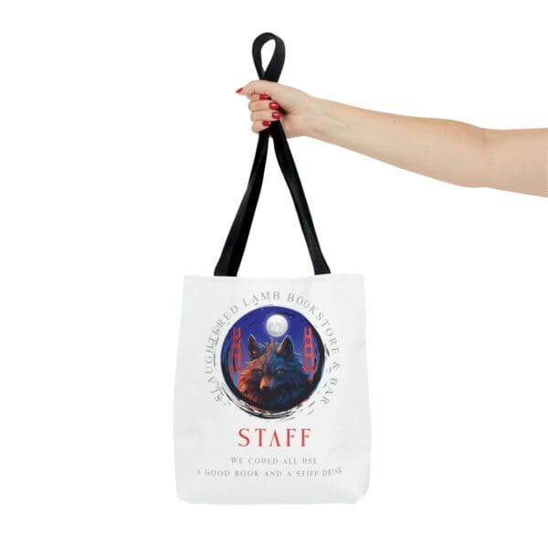 A hand holding a bag with the word staff on it.