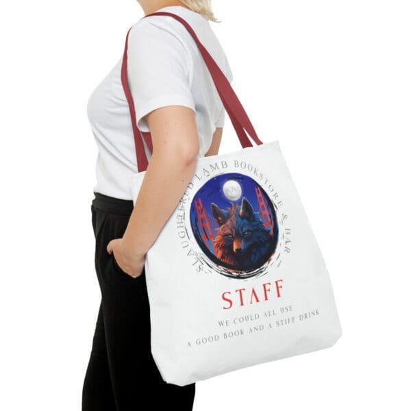 A woman is holding onto a bag with the word staff on it.