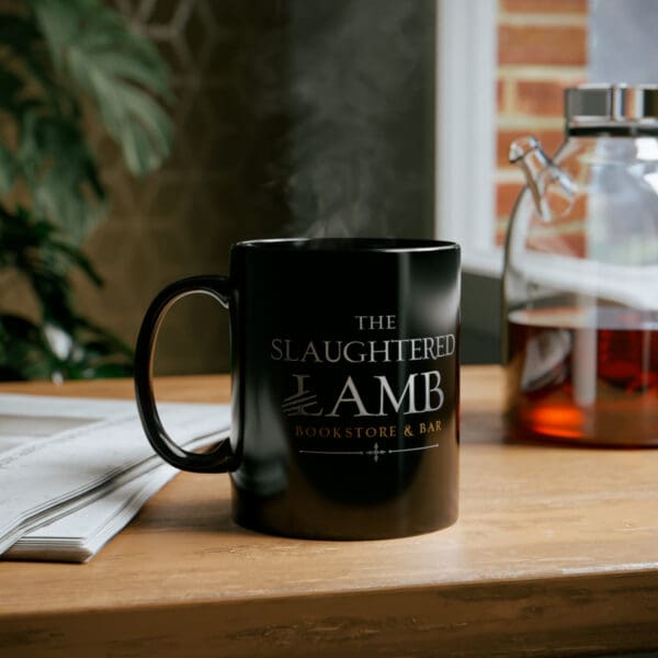 A black mug sitting on top of a wooden table.